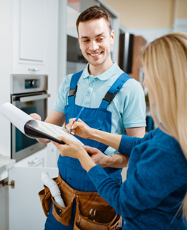 Male plumber and female customer in the kitchen